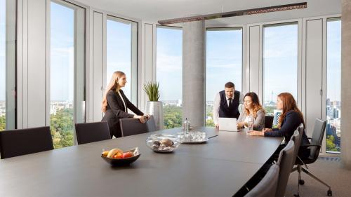 Business-Meeting im Upper West Tower am Kurfürstendamm 11, Berlin Charlottenburg. Büro mieten mit modernen Möbeln, großen Fenstern und Stadtausblick.