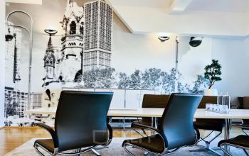 Gemütlicher Besprechungsraum im Büro am Kurfürstendamm 194, Berlin Charlottenburg, mit modernen Sitzmöbeln und künstlerischer Wanddekoration. Perfekt für Meetings, hier kannst du flexibel einen Büroraum mieten.