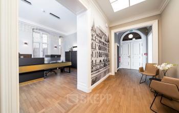 Modernes Büro in Berlin Charlottenburg, Kurfürstendamm 15 mit Holzboden, dekorativen Wandbildern und eleganten Möbeln, ideal zur Bürofläche mieten.