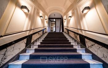 Eingangsbereich im Bürogebäude Kurfürstendamm 15 in Berlin Charlottenburg mit eleganter Treppe und stilvoller Beleuchtung. Eine ideale Option für büroraum mieten.