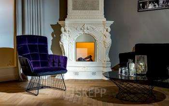 Eleganter Büroraum mit Kamin in Kurfürstendamm 15, Berlin Charlottenburg, modernes Design, lila Sessel und Glastisch, ideal zum Büroraum mieten.