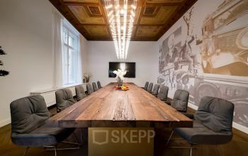 Büroraum mieten im Kurfürstendamm 15, Berlin Charlottenburg: Stilvoll eingerichteter Konferenzraum mit Holztisch, moderner Beleuchtung und Wandkunst, perfekt für Meetings.