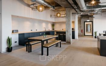 Moderner Büroinnenraum in der Köpenicker Straße 40-41, Berlin Friedrichshain mit großen Tischen und Pflanzen, eignet sich perfekt zum Büroraum mieten.