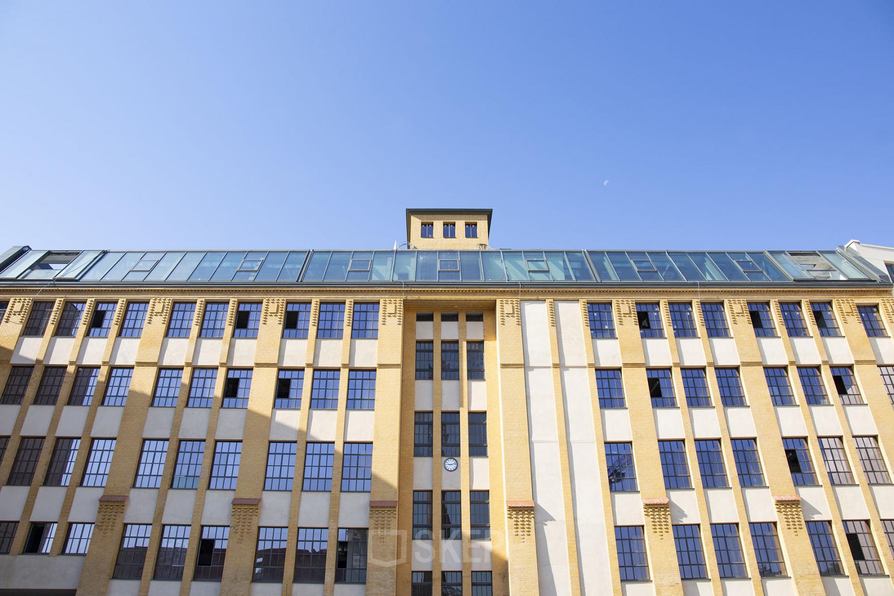Das Bürogebäude in der Köpenicker Straße 40-41, Berlin Friedrichshain, zeigt eine historische Fassade mit großen Fenstern und einem modernen Obergeschoss.