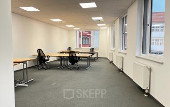 Leerer Büroraum zur Miete in der Rigaer Straße 71a, Berlin Friedrichshain, mit mehreren Schreibtischen und Stühlen, gut beleuchtet durch große Fenster.