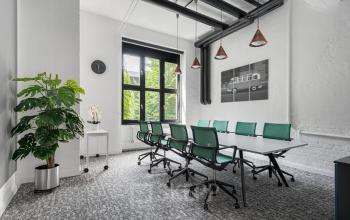 Modernes Büro in der Edisonstraße 63, Berlin Köpenick. Geräumiger Konferenzraum mit großem Tisch und grünen Bürostühlen zur Miete.