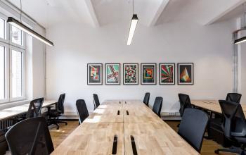 Modern office space to rent at Skalitzer Straße 104 in Berlin Kreuzberg with large wooden desks, ergonomic chairs, and colorful artwork on the walls.