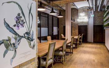 Spacious and stylish office for rent at Skalitzer Straße 104, Berlin Kreuzberg, featuring long wooden tables, industrial décor, and ample lighting.