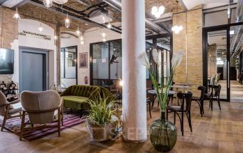 Stylish furnished office space rental with modern lighting, cozy seating, and exposed brick walls at Skalitzer Straße 104, Berlin Kreuzberg.