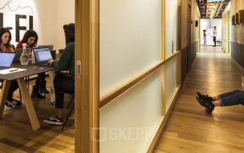 Arbeitsplätze in offenem Büro und modern designter Flur