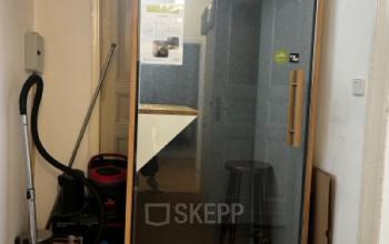 Innenansicht eines einfachen Büroraums mit Staubsauger und Hockern, ideal für Büroraum mieten in Berlin Kreuzberg.