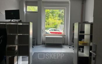 Ein einfaches Büro in der Wrangelstraße 22, Berlin Kreuzberg, mit zwei weißen Regalen und einem Computerbildschirm, ideal, um Büroraum zu mieten.