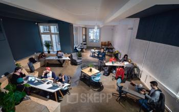 Modernes Büro in Berlin Kreuzberg, Rudi-Dutschke-Straße 23, zeigt verschiedene Bereiche mit Schreibtischen und Personen bei der Arbeit. Ideal für büroraum mieten mit flexibler Nutzung.