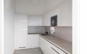 Kleine Pantry im Büro zur Miete in Mehringdamm 33, Berlin Kreuzberg, ausgestattet mit Mikrowelle, Spüle und Schränken.