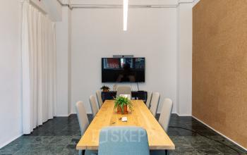 Moderner Konferenzraum im Bürogebäude Mehringdamm 33, Berlin Kreuzberg, ausgestattet mit großem Tisch, Stühlen und TV-Bildschirm. Ideal für Meetings und Präsentationen. Perfekt für Unternehmen, die Bürofläche mieten möchten.