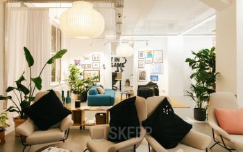Modernes Büro in Mehringdamm 33, Berlin Kreuzberg, mit bequemen Stühlen, Kunstwerken an den Wänden und grünen Pflanzen. Ideal zum Büroraum mieten.