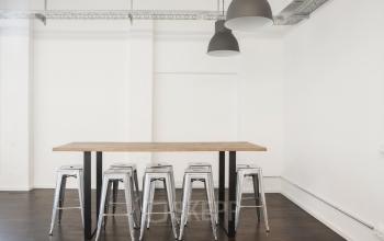 Minimalistischer Büroraum mieten in der Mehringdamm 33, Berlin Kreuzberg, mit Stehtisch und Barhockern.