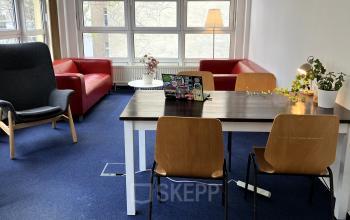 Gemütlicher Büroraum in Berlin Kreuzberg mit Tisch, Stühlen und Sofa für eine entspannte Arbeitsatmosphäre. Bürofläche mieten leicht gemacht.