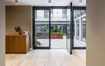 Heller Eingangsbereich in der Chausseestraße 29, Berlin Kreuzberg, mit Blick ins Freie. Ideal für Firmen, die Bürofläche mieten möchten.