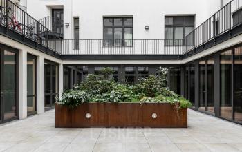 Innenhof mit grünem Pflanzbeet in der Chausseestraße 29, ideal für die Pause beim Büro mieten oder Büroraum mieten in Berlin Kreuzberg.