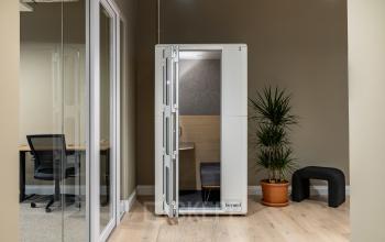 Modernes Büro mit schallisolierter Kabine, ideal für konzentriertes Arbeiten. Die Bürofläche in der Chausseestraße 29, Berlin Kreuzberg, bietet diesen cleveren büroraum mieten Service.