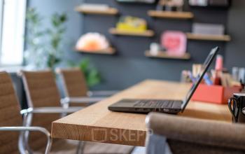 Büro in Unter den Linden 26-30, Berlin Mitte, mit modernen Möbeln und einem hölzernen Konferenztisch, auf dem ein Laptop steht.
