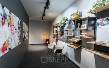 Modernes Büro in Unter den Linden 26-30, Berlin Mitte mit Wandregalen und zwei weißen Stühlen.