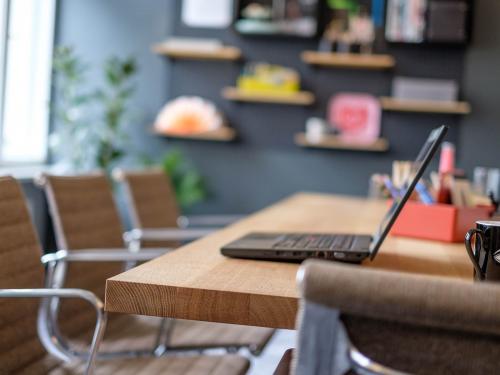 Büro in Unter den Linden 26-30, Berlin Mitte, mit modernen Möbeln und einem hölzernen Konferenztisch, auf dem ein Laptop steht.