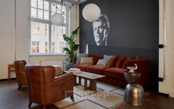 Gemütlicher Büroraum in der Krausenstraße 9, Berlin Mitte, mit stilvollen Ledersesseln und einem großen Sofa. Perfekt zum Büroraum mieten.