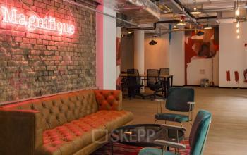 Sitzecke zum Entspannen und Coworking-Bereich im Hintergrund