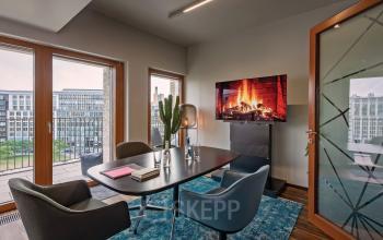 Moderner Büroraum mieten am Leipziger Platz 16, Berlin Mitte, mit Blick auf die Stadt, ausgestattet mit einem Tisch, Stühlen und einem großen Bildschirm.