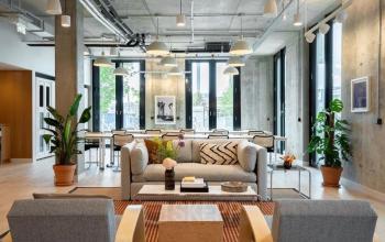 Moderner Büroraum in der Dircksenstraße 3, Berlin Mitte: Helle, offene Bürofläche mit stilvollen Möbeln, ideal zum Büro mieten. Pflanzen und gemütliche Sitzmöglichkeiten schaffen eine einladende Atmosphäre.