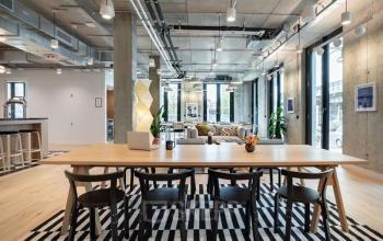 Moderner Büroraum in der Dircksenstraße 3, Berlin Mitte mit hellem Holzboden, langen Tischen und großen Fenstern. Ideal, um Bürofläche im Herzen von Berlin Mitte zu mieten.