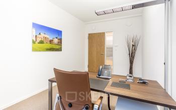 Modernes Büro mieten in Berlin Mitte, Pariser Platz 6a, mit schlichtem Schreibtisch und bequemen Stuhl, ideal für konzentriertes Arbeiten.