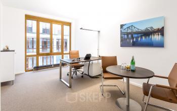 Modernes Büro mit großen Fenstern am Pariser Platz 6a in Berlin Mitte. Möblierte Bürofläche mieten mit Schreibtischen und Besprechungstisch.