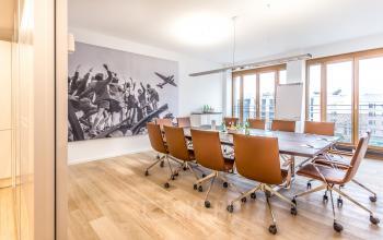 Konferenzraum zur Bürofläche mieten in Berlin Mitte, Pariser Platz 6a, mit modernen braunen Stühlen und großem Tisch.
