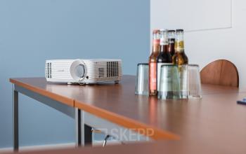 Konferenzraum in An der Kolonnade 11, Berlin Mitte, mit Holztisch, Projektor und Getränken. Bürofläche mieten.
