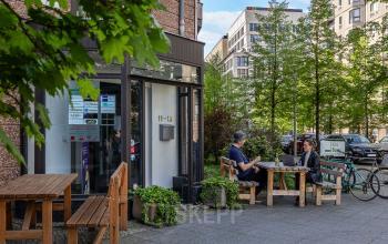 Zwei Personen sitzen draußen vor einem Gebäude in An der Kolonnade 11, Berlin Mitte, und arbeiten an Laptops. Perfekt für ein Büro mieten in einer lebhaften Umgebung.