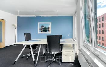 Helles, modernes Büro in Potsdamer Platz 10, Berlin Mitte mit blau gestrichener Wand und großen Fenstern.