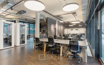 Modern office space rental at Hussitenstraße 32, Berlin Mitte, featuring open desks, chairs, and large windows.