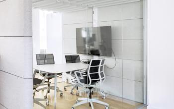 Moderner Konferenzraum im Büro zur Miete in der Neue Grünstraße 17, Berlin Mitte, mit Glaswänden, einem großen Tisch und Bürostühlen.