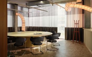 Modernes Büro zur Miete in Karl-Liebknecht-Straße 29a, Berlin Mitte, mit großem runden Besprechungstisch, Stühlen und moderner Beleuchtung.