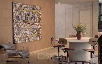 Büroraum mit einem modernen Kunstwerk an der Wand in Karl-Liebknecht-Straße 29a, Berlin Mitte. Runde Tischgruppe mit Stühlen, neutraler und professioneller Look.