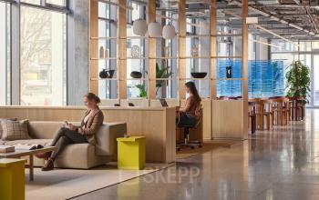 Moderne Bürofläche mieten in der Karl-Liebknecht-Straße 29a, Berlin Mitte, mit stilvollem Interieur und natürlichem Licht, Personen arbeiten konzentriert an Schreibtischen.