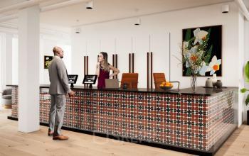 Empfangsbereich im Bürogebäude Rosenthaler Straße 43-45 in Berlin Mitte, wo zwei Personen an der Rezeption interagieren. Büro mieten an zentraler Lage.