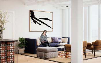 Modernes Büro in der Rosenthaler Straße 43-45, Berlin Mitte. Eine Person arbeitet konzentriert auf einem Laptop im gemütlichen Lounge-Bereich des Büros.