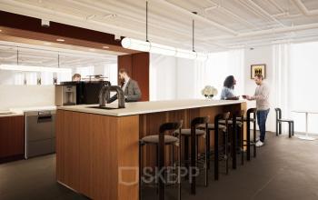 Modernes Büro in der Rosenthaler Straße 43-45, Berlin Mitte, mit großzügigem Lounge-Bereich und stilvoller Einrichtung. Personen unterhalten sich an den Tischen und sitzen an der Küchenzeile.