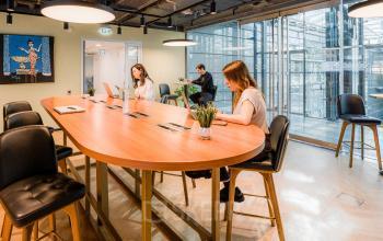 Arbeitsbereich im Bürogebäude Linkstraße 2, Berlin Mitte, mit mehreren Personen, die an Laptops arbeiten.