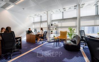 Modernes Büro in Berlin Mitte, Linkstraße 2, mit mehreren Arbeitsplätzen und natürlichem Licht, wo Menschen geschäftlich tätig sind.