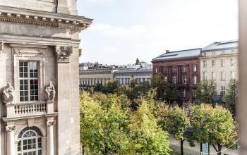 Blick auf historische Fassaden und Bäume entlang der Straße Unter den Linden 10 in Berlin Mitte.